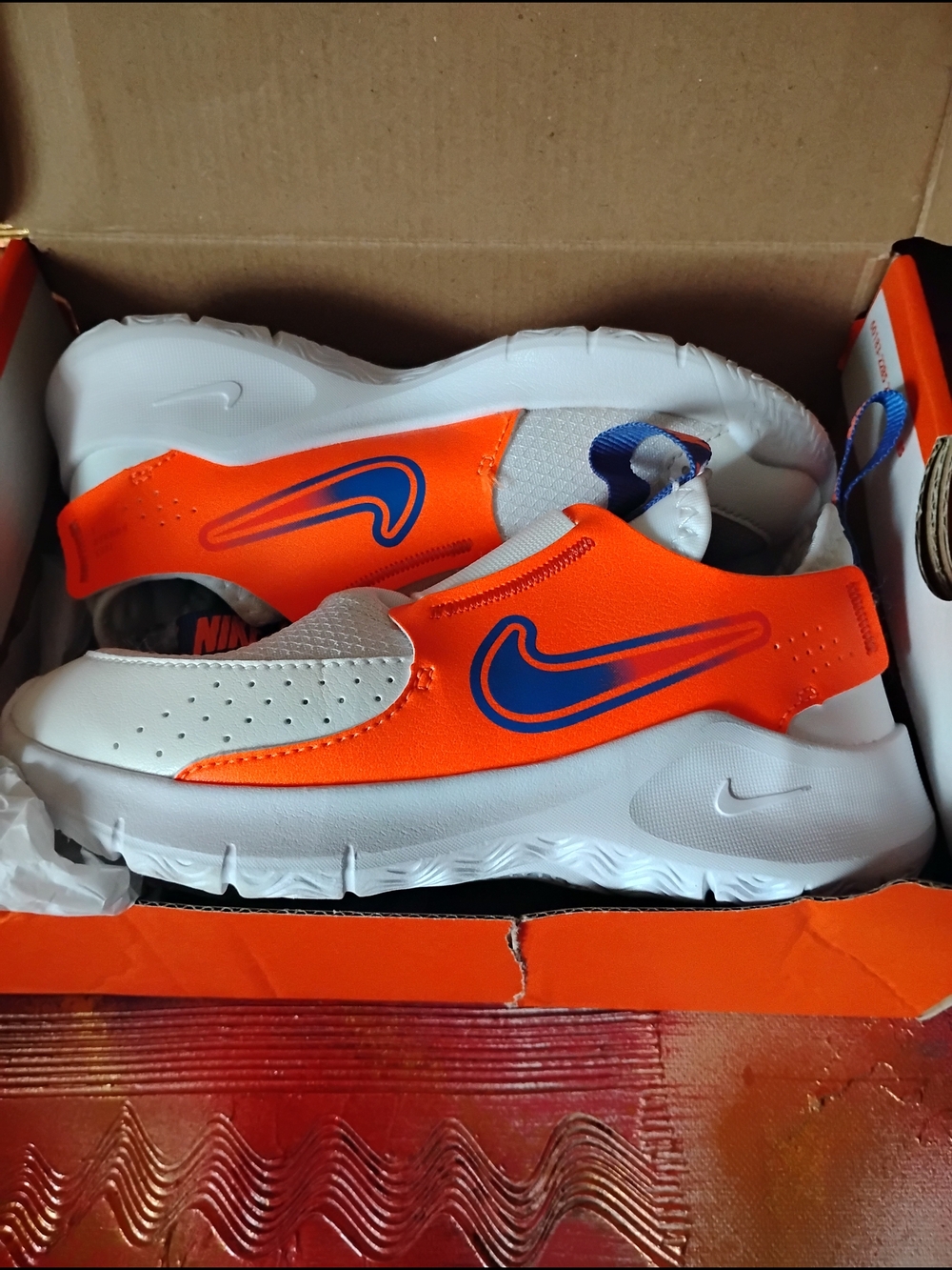 Nike Kids Slip-On Sneakers in White & Bright Orange with Blue Swoosh